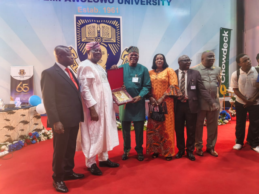 Gbenga Elegbeleye receiving OAU Outstanding Leadership Award through Deputy Vice-Chancellor Prof. Oluropo Akinfala